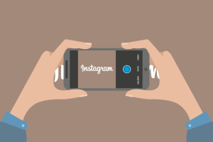 Desenho de duas mãos segurando celular em posição de tirar foto e texto escrito "instagram" na tela