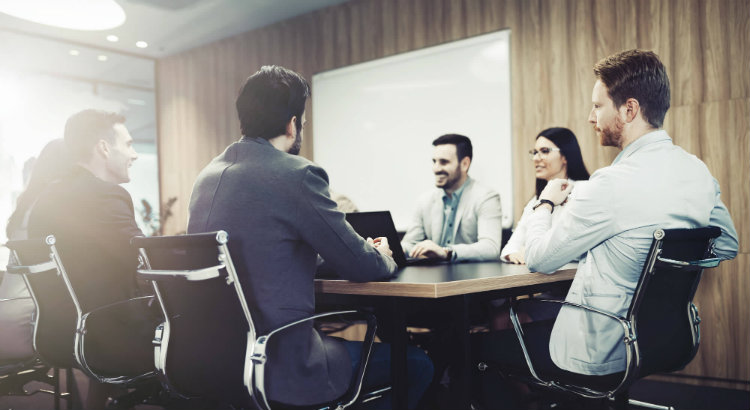 Imagem de sala de reunião com quatro homens e uma mulher ilustrando como aplicar a metodologia ágil em um escritório de advocacia