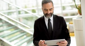 Homem de barba segurando tablet lendo sobre tecnologias para advogados que você deve conhecer