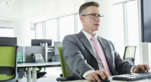 homem com terno e gravata em frente ao computador ilustrando o que precisa saber sobre marketing jurídico