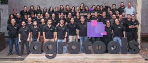 Foto da equipe da Agrotools, com homens e mulheres em pé, vestidos de preto, atrás do nome da empresa