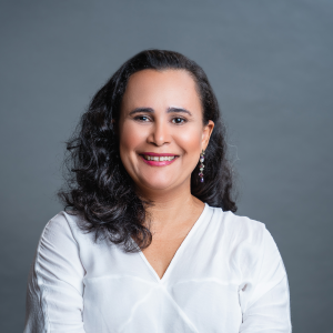 Foto de Cristiane Gomes, mulher branca de cabelos escuros na altura do ombro